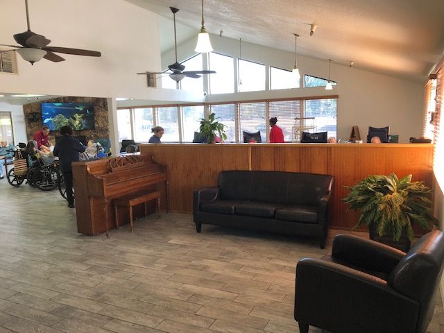 A lobby area with seating, a reception desk, and indoor plants.