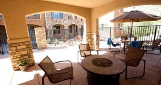 A cozy outdoor patio with a fire pit and comfortable seating in a residential setting.