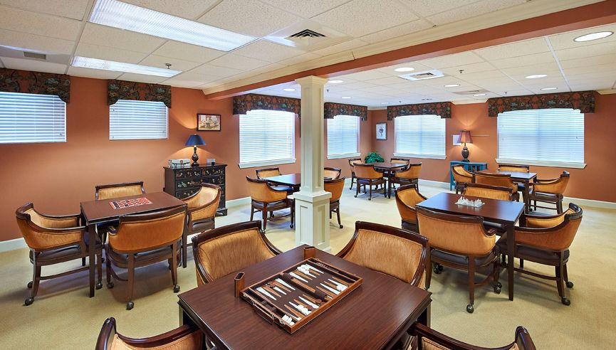 A cozy game room featuring tables and chairs, complete with a backgammon set for relaxation and entertainment.
