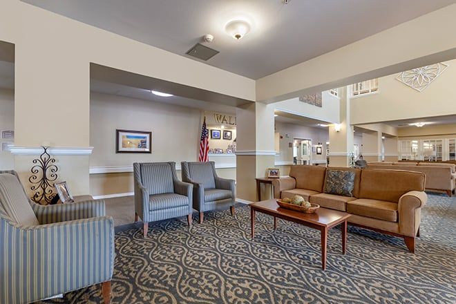 A well-furnished lobby with seating and decor, featuring chairs, a sofa, and a coffee table.