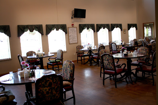 A spacious dining room with decorative furniture and large windows allowing natural light.