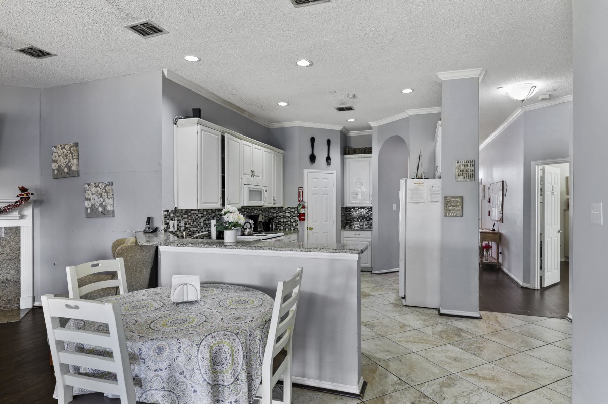 A modern kitchen and dining area featuring white cabinets and contemporary decor.