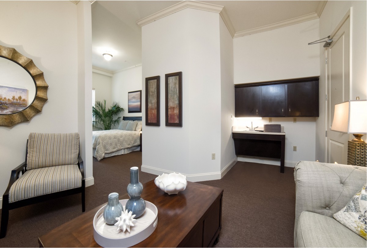 A modern living space with a view into the bedroom, featuring sleek furniture and stylish decor.
