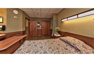 A clean and comfortable hospital room with a bed and bright lighting.