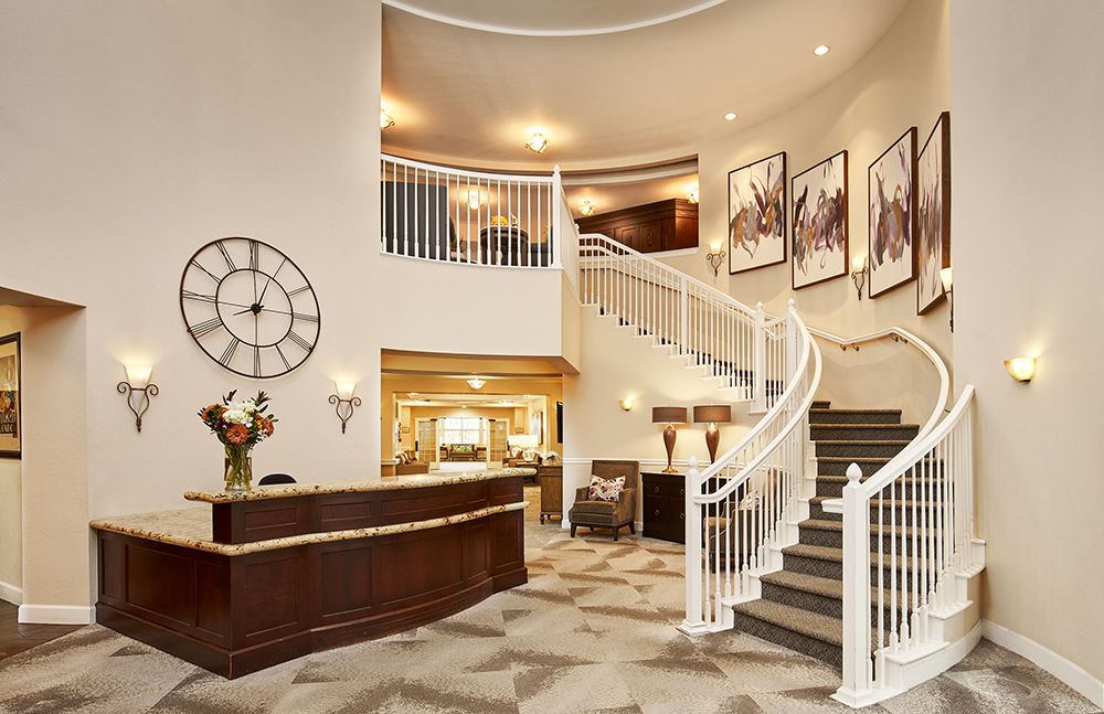 A luxurious hotel lobby featuring a grand curved staircase and elegant reception area.