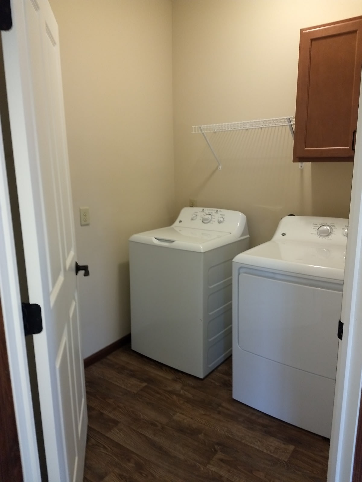 A compact laundry room featuring a washer and dryer side by side.