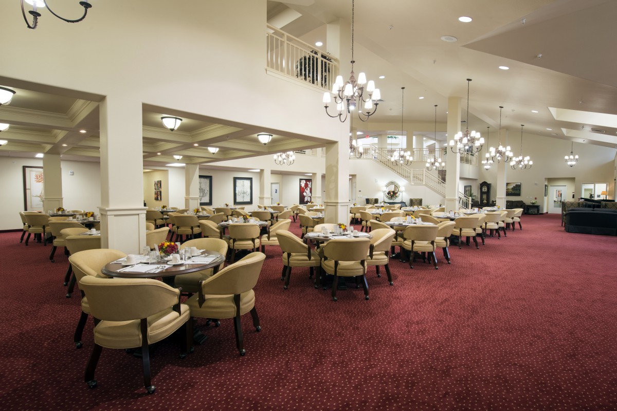 Elegant dining area with chandeliers and plush carpeting.