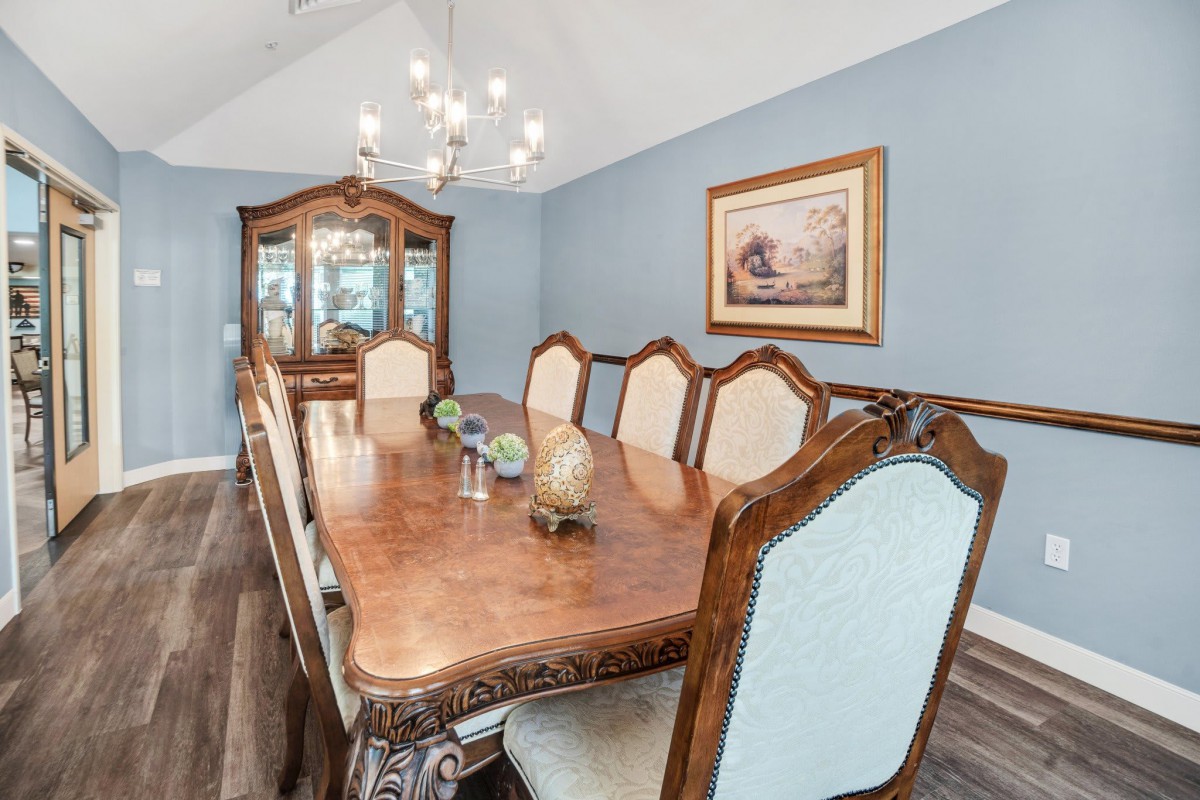 A classic dining room with a wooden table, ornate chairs, and a chandelier.