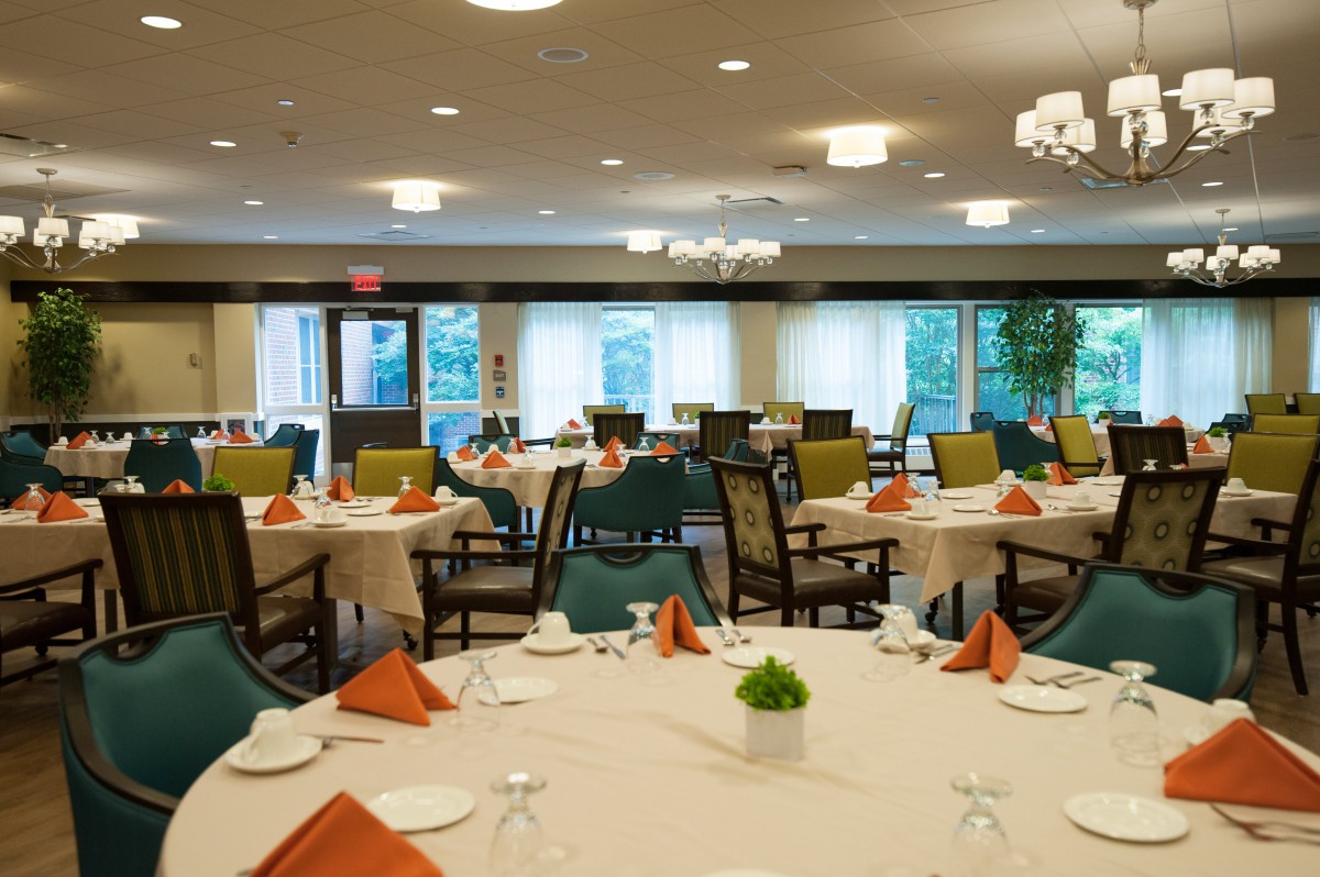 A spacious and elegantly set dining room with neatly arranged tables and chairs.