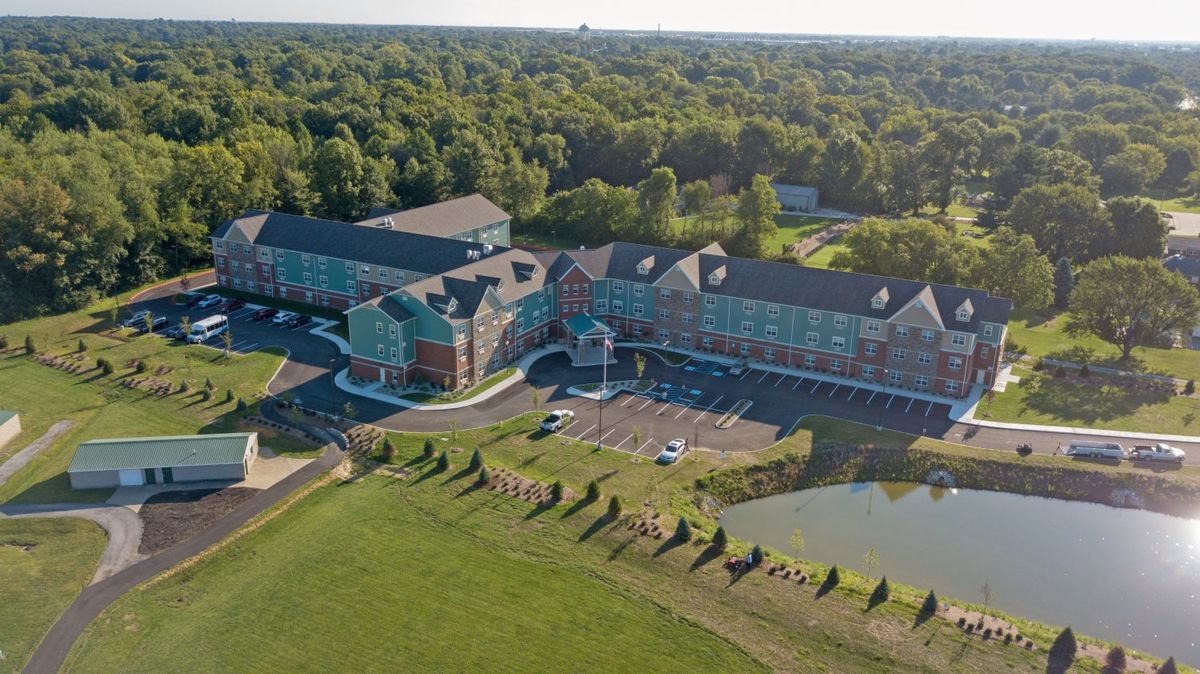 Aerial view of a large hotel complex surrounded by trees and a pond.