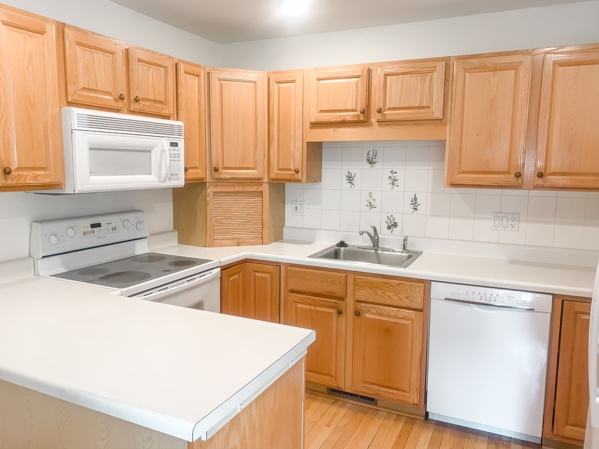 A modern kitchen with wooden cabinets and a variety of appliances.