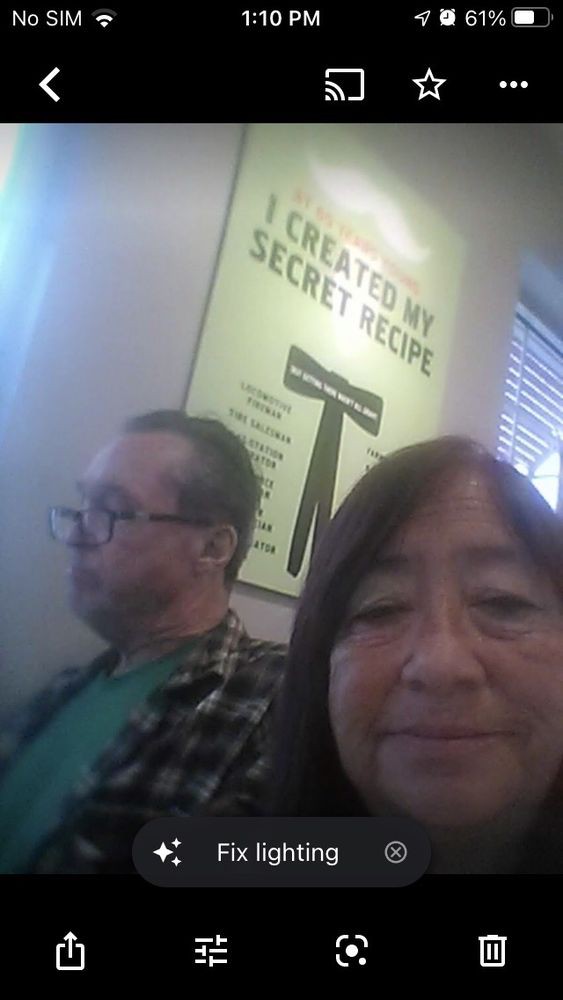 A selfie taken indoors near a poster.