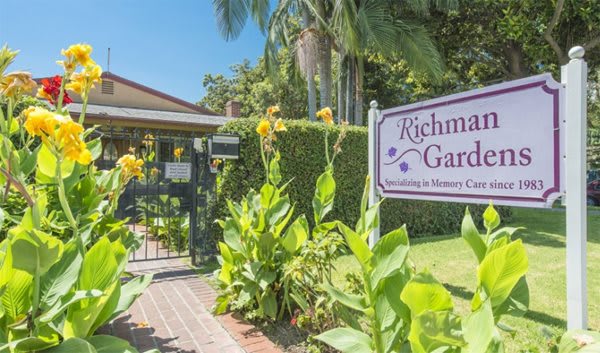 Entrance to Richman Gardens with vibrant yellow flowers and welcoming greenery.