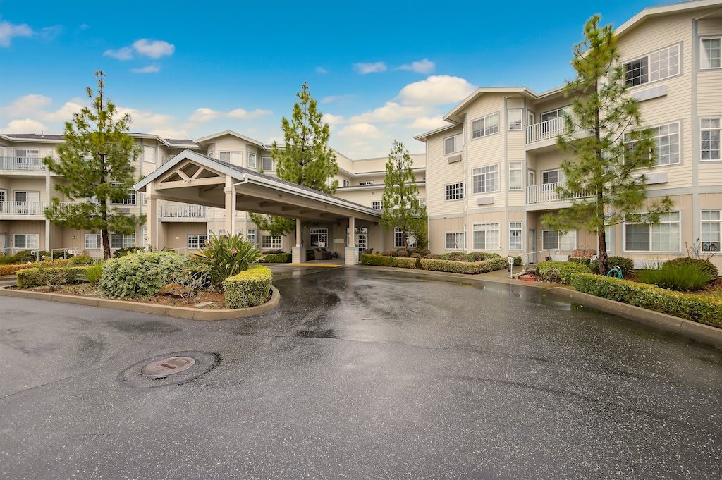 A residential apartment complex with a driveway and landscaped surroundings.