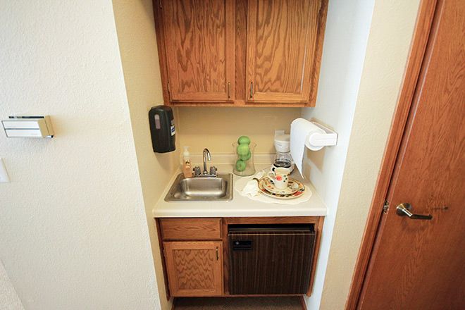 A small kitchenette area with a sink, cabinets, and countertop.