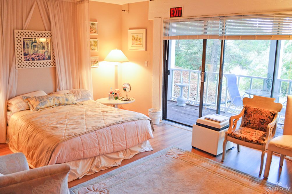 A cozy bedroom with soft lighting and access to a balcony.