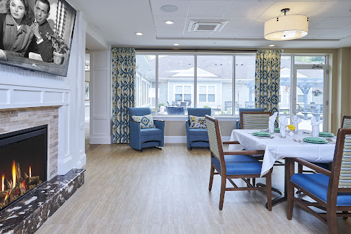 A bright and modern dining area featuring blue chairs, large windows, and a cozy ambiance.
