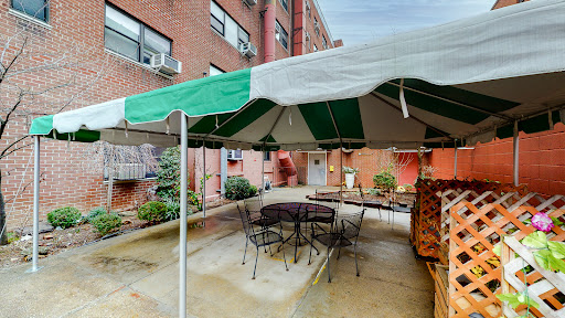 A cozy outdoor patio area with a green and white striped tent, seating arrangements, and a relaxing ambiance.
