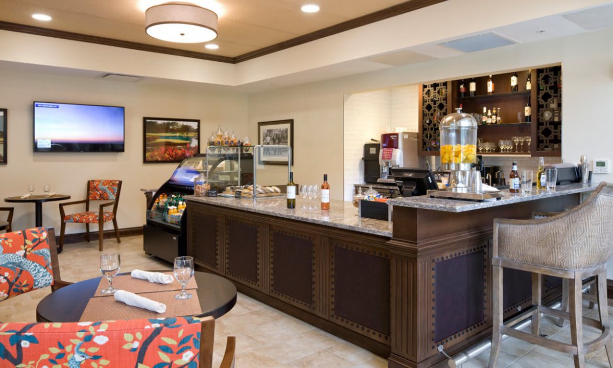 Interior view of a cafe with a beverage station and seating area.