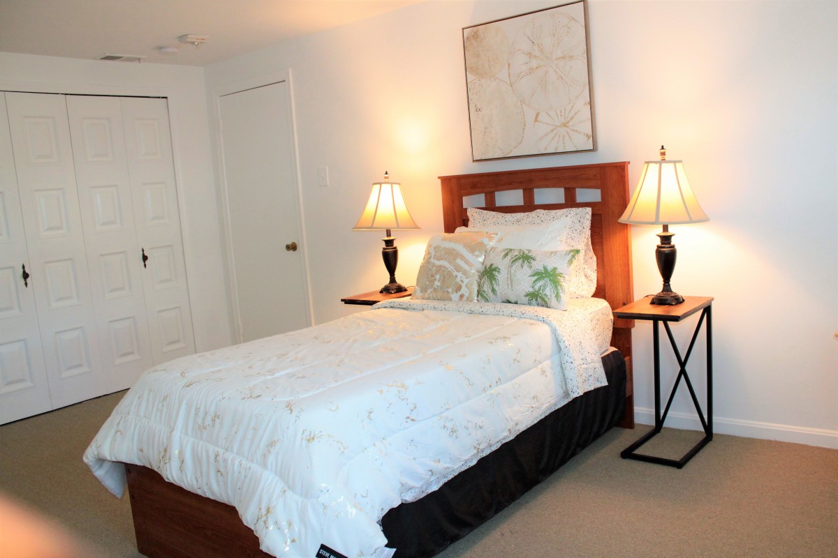 A cozy bedroom with a neatly made bed and two lamps on side tables.