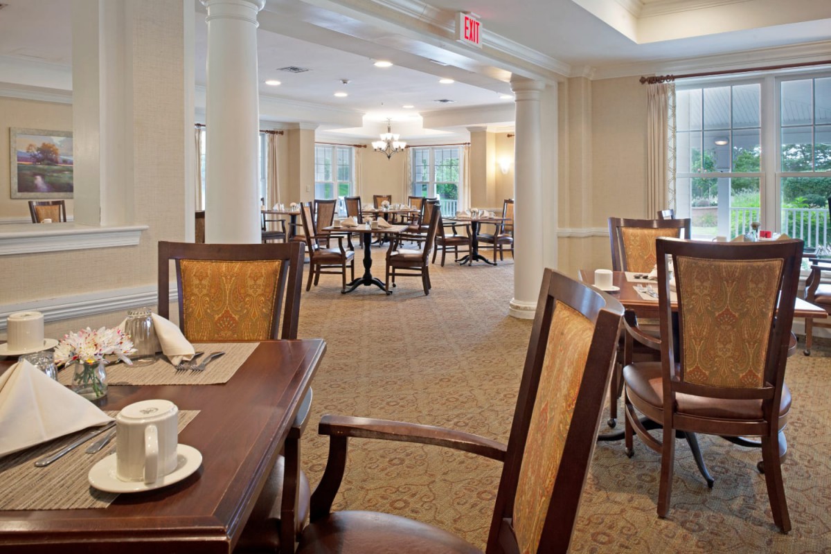 An elegant dining area with neatly arranged tables and chairs, featuring a warm and welcoming atmosphere.