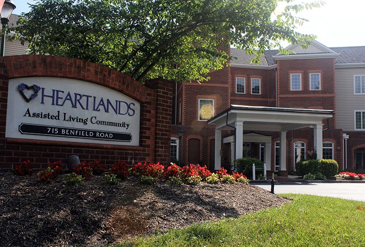 Entrance of Heartlands Assisted Living Community with a well-maintained garden and prominent signage.