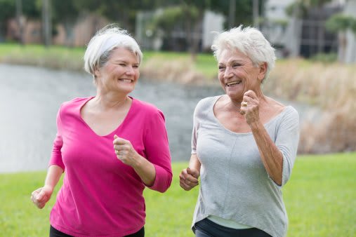 Two elderly women enjoying a walk together outdoors.