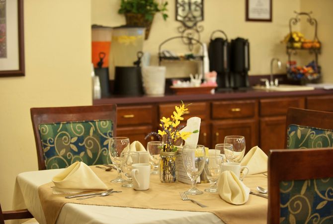 A dining table elegantly set with napkins, glasses, and flowers in a restaurant.