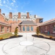 A brick courtyard surrounded by buildings under a clear blue sky.