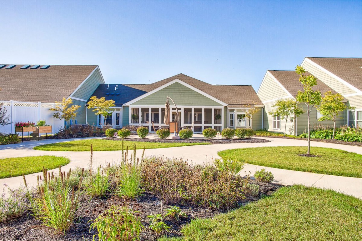 A residential building with well-maintained landscaping under a clear blue sky.