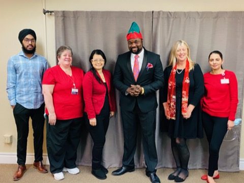 A diverse team gathered for a festive occasion, showcasing unity and celebration in a professional environment.