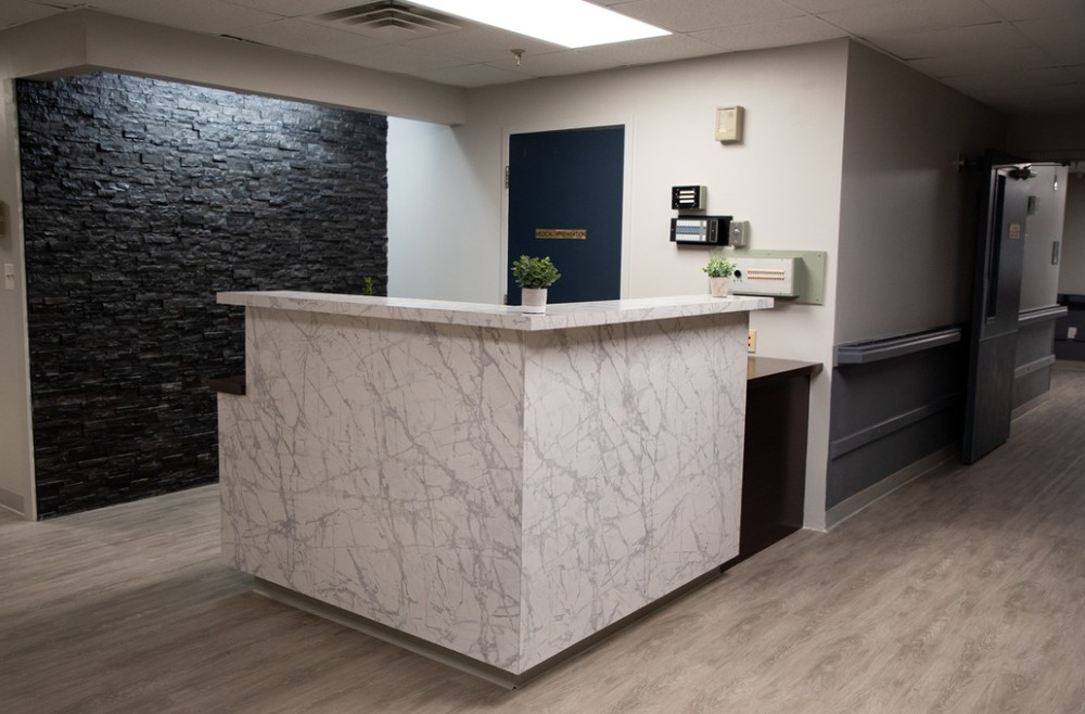 A modern reception desk made of marble in an office lobby.