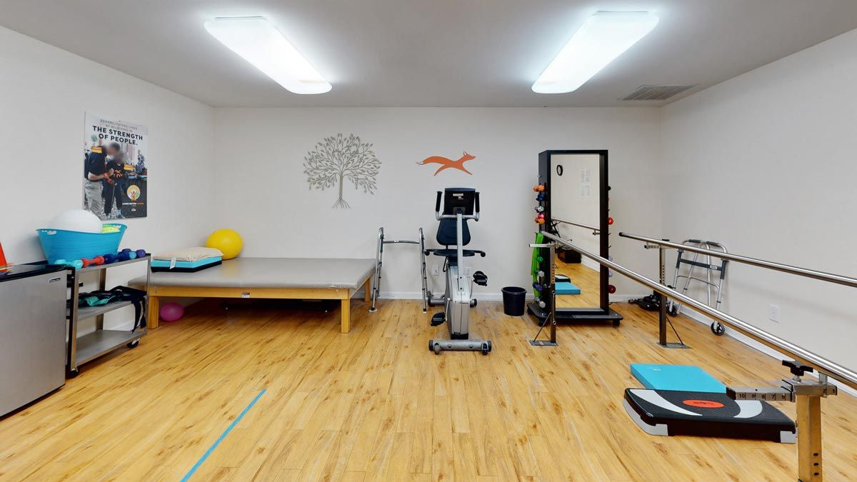 A clean and well-lit exercise room featuring a variety of fitness equipment.