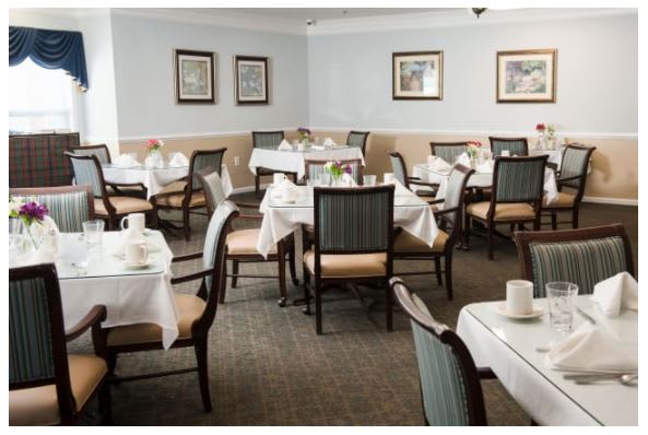 An empty dining room with tables set for guests.