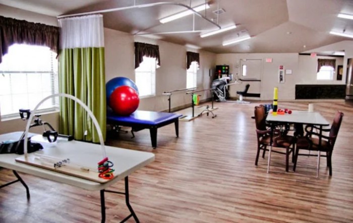 A spacious therapy room equipped with exercise equipment for rehabilitation and physical therapy sessions.