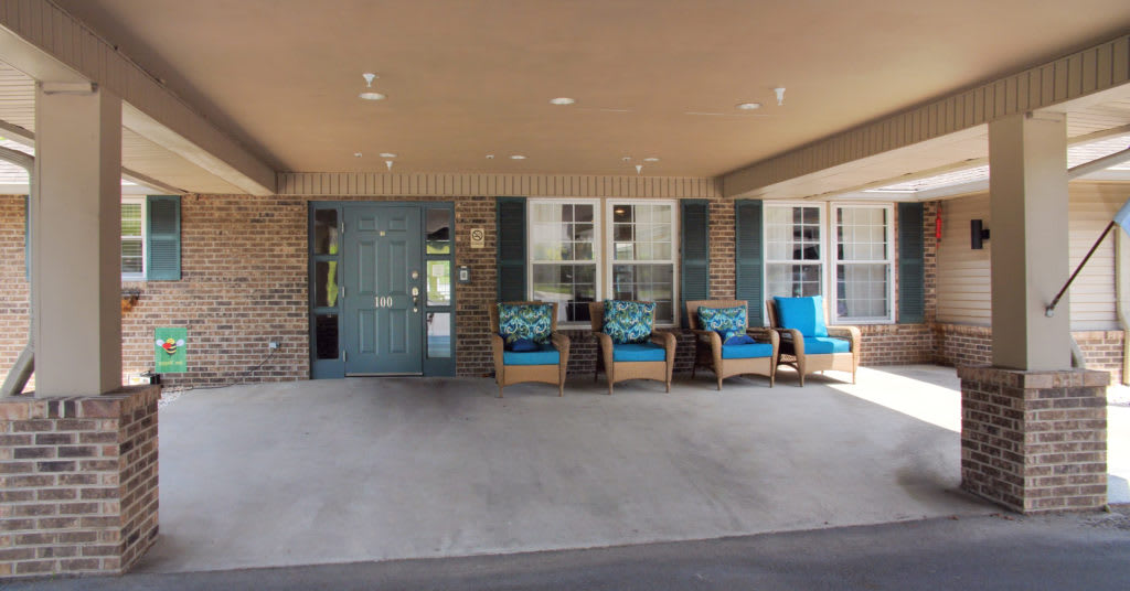 A cozy porch area with seating and a blue door.