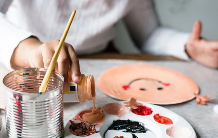 An artist carefully mixes watercolor paints while working on a portrait.