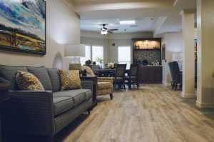 A cozy living room with a sofa and dining area, featuring hardwood flooring and modern decor.