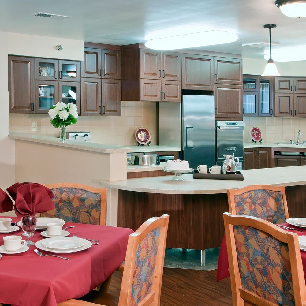 A cozy kitchen and dining area with wooden cabinets and a table set for dining.