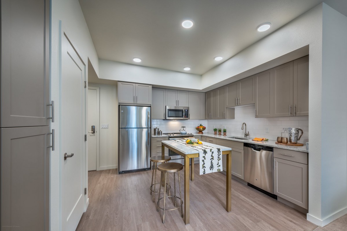 A modern kitchen with stainless steel appliances and a central island.