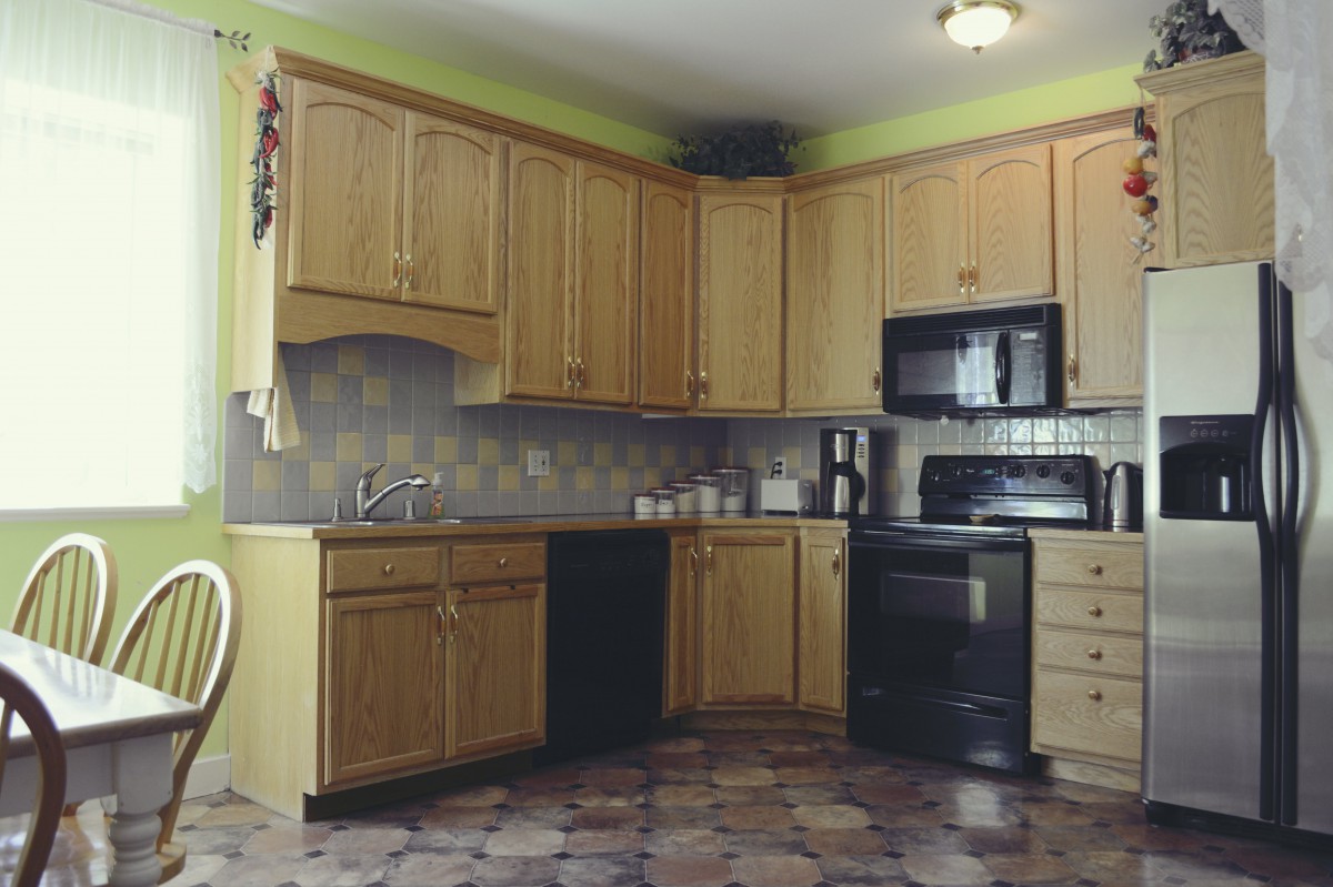 A modern kitchen with wooden cabinets and black appliances.