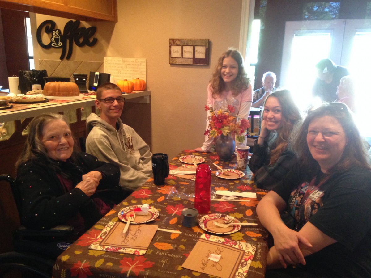 A group of people enjoying a casual gathering around a dining table decorated for autumn.