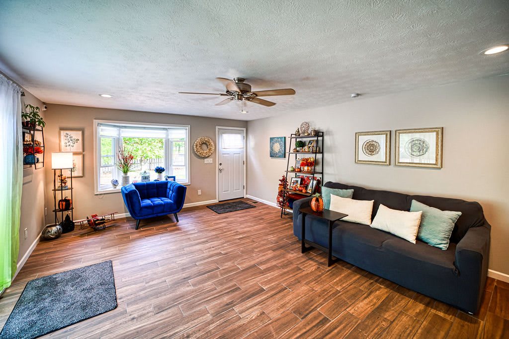 Modern living room with a comfortable sofa, armchair, and wood flooring.