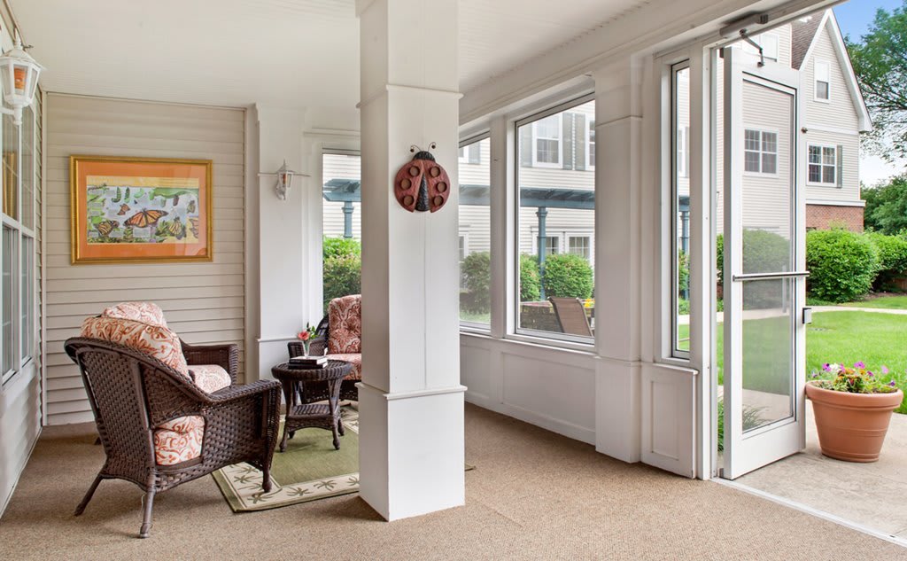 A cozy sunroom with comfortable seating and large windows allowing abundant natural light.