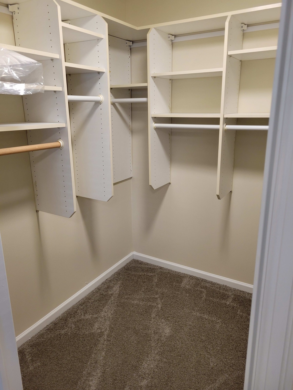 An empty walk-in closet with shelves and hanging space.