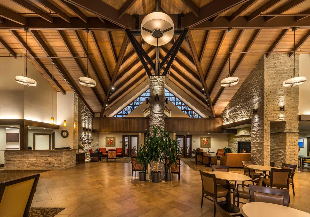 A spacious and elegantly designed lobby with wooden beams and modern lighting.