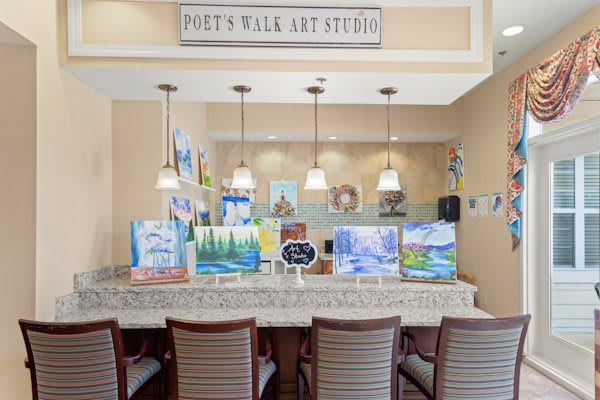 An inviting art studio setup with paintings on display, comfortable seating, and elegant lighting.