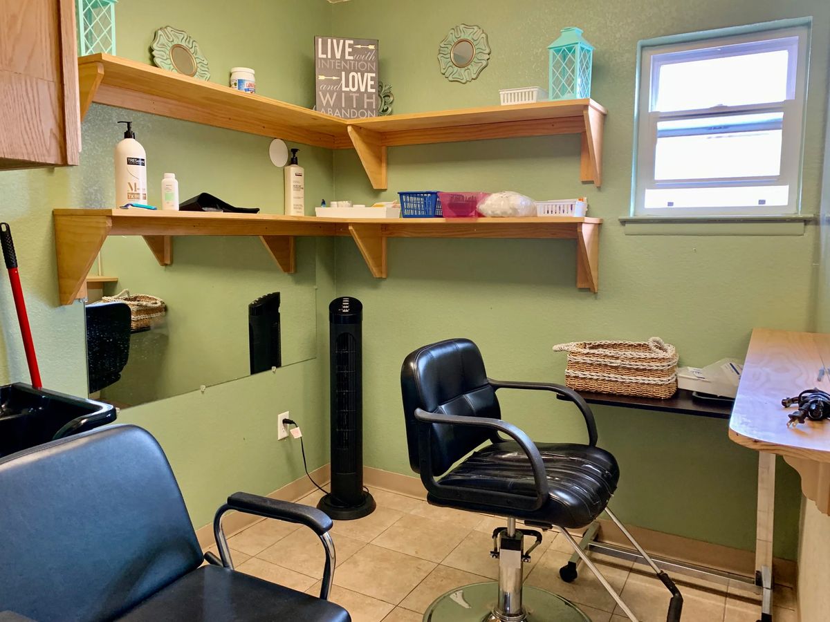 A cozy salon interior with barber chairs and shelves stocked with hair products.