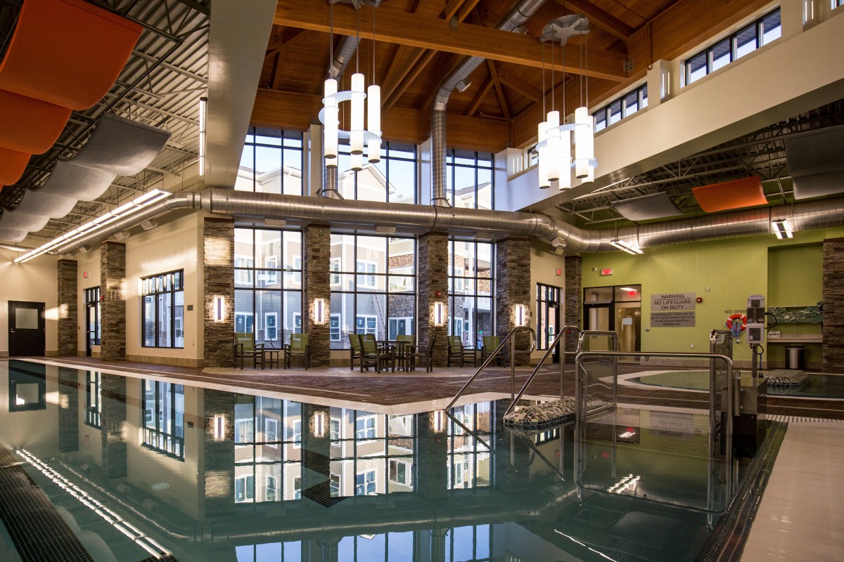 A spacious indoor pool area with modern architecture and large windows providing natural light.