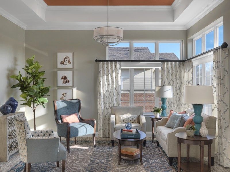 A cozy and elegantly designed living room with ample natural light, featuring modern furniture and decor.